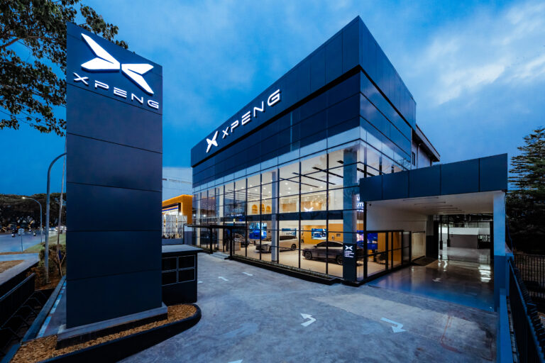 Showroom XPENG Alam Sutera pada sore hari dengan papan logo menyala dan pintu masuk utama.